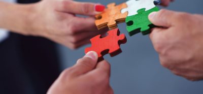 a group of people putting pieces of a puzzle together.