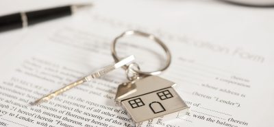 a house keychain sitting on top of a piece of paper.