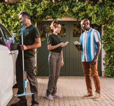 A man making a transaction with Zelle to two people in a driveway.